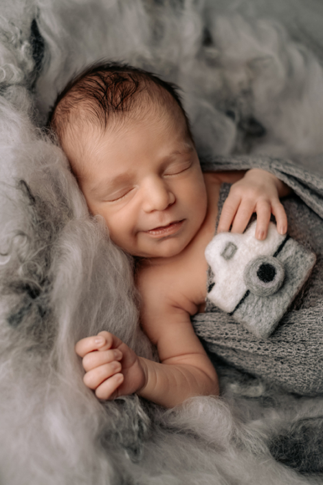 servizio fotografico neonati venezia - newborn con macchina fotografica in lana cardata