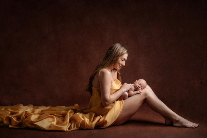 servizio fotografico neonati _ mamma con bambino sulle gambe
