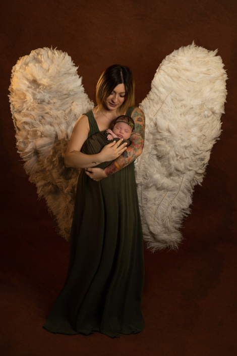 servizio fotografico neonati venezia _ mamma con ali da angelo mentre abbraccia la figlia
