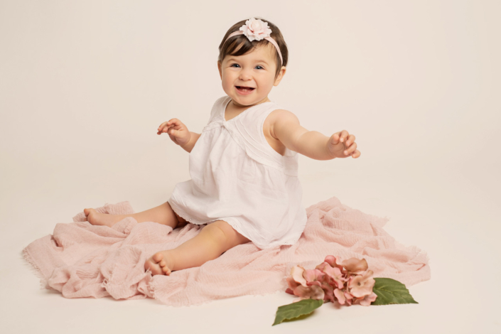 servizio fotografico sitter - bambina di 8 mesi con fiori rosa